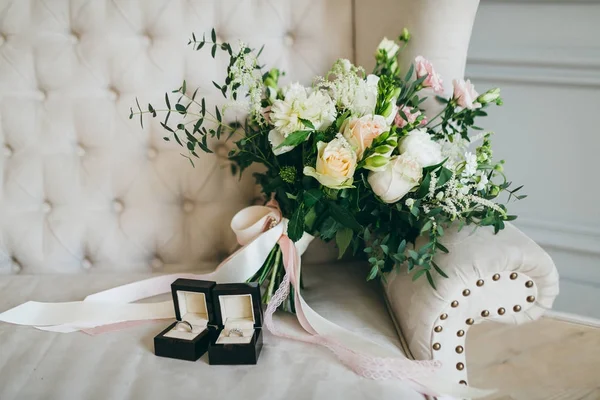 Ramo de boda rústico y anillos en la caja negra en un sofá de lujo. En interiores. Obra de arte — Foto de Stock