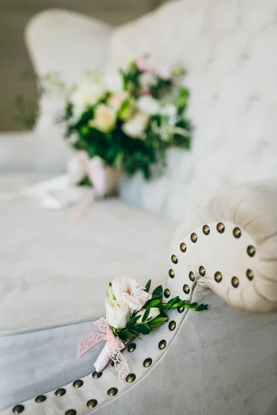 Noivos boutonniere de flores e verdes encontra-se no sofá de luxo. Obra de arte — Fotografia de Stock