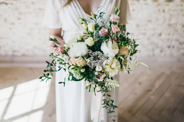 Precioso ramo de flores blancas y rosadas en las manos de la encantadora novia en un vestido blanco. Obra de arte — Foto de Stock