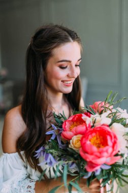 Neşeli, genç gelin bir rustik düğün buketi beyaz güller ve Kızıl peonies ile tutar. Yakın çekim portre. Çiçek bir demet mutlu bir kızla