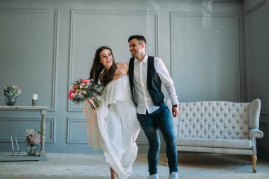 Neşeli gelin ve damat birlikte eğleniyor. Yeni evliler gülüyor ve go crazy. Sanat. Kapalı düğün. Yumuşak odak