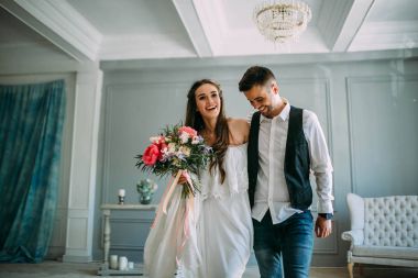 Neşeli gelin ve damat birlikte eğleniyor. Yeni evliler gülüyor ve go crazy. Sanat. Kapalı düğün. Yumuşak odak