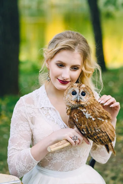 El búho se sienta en la mano de las chicas. La novia con el búho . — Foto de Stock