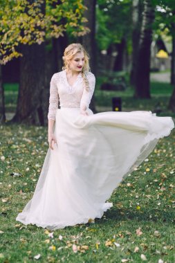Mutlu gelin elbise doğa çırpınan poz. Sanat