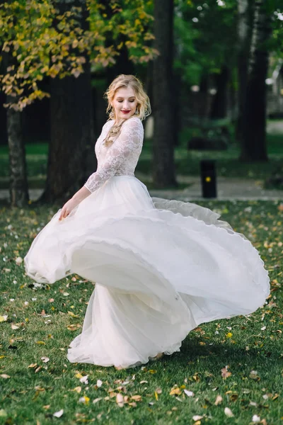 La belle mariée tourne autour d'elle en danse. femme pose en robe volante à l'extérieur. Oeuvres — Photo