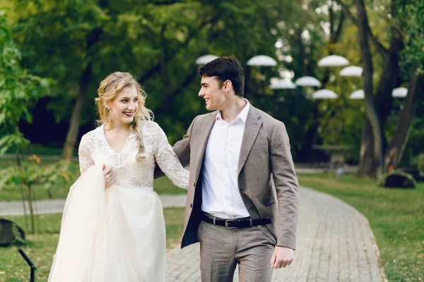 Sposi che camminano nel parco. Sposa e sposo si guardano. Matrimonio d'autunno. Opera d'arte — Foto Stock