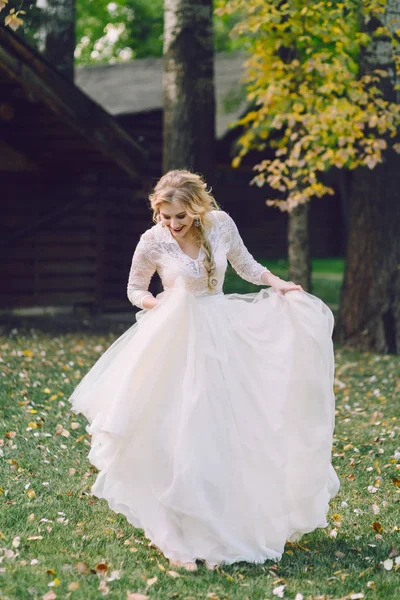 Счастливая невеста позирует в трепещущем платье на природе. Озил работает — стоковое фото