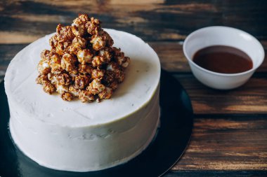 Cheesecake ile karamelli patlamış mısır ve ahşap arka plan üstten görünüm üzerinde çikolata ayyaş. Sanat.