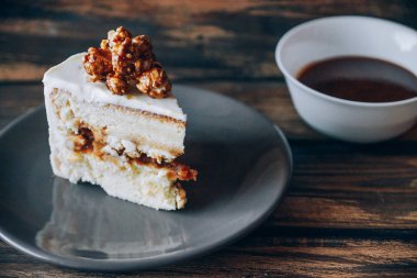 Ahşap zemin üzerine karamelli patlamış mısır ile tepesinde cheesecake dilim. Sanat.