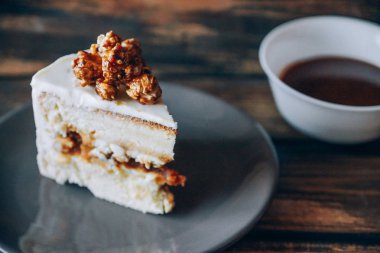 Ahşap zemin üzerine karamelli patlamış mısır ile tepesinde cheesecake dilim. Sanat. Karamelli patlamış mısır yumuşak odak