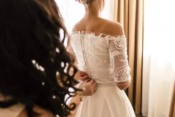 A mãe ajuda a fixar um vestido de casamento a noiva antes da cerimônia. Conceito de casamento. Obra de arte — Fotografia de Stock