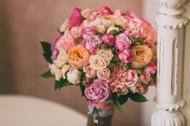 Gelin buketi pembe Gül ve şeftali peonies duvar arka plan üzerinde duruyor