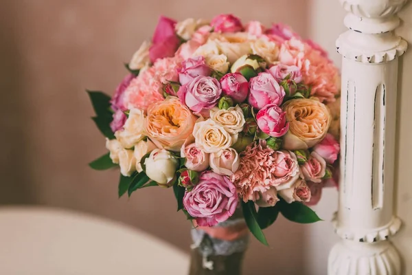 Buquê de noiva com rosas rosa e peônias de pêssego fica no fundo da parede vintage — Fotografia de Stock