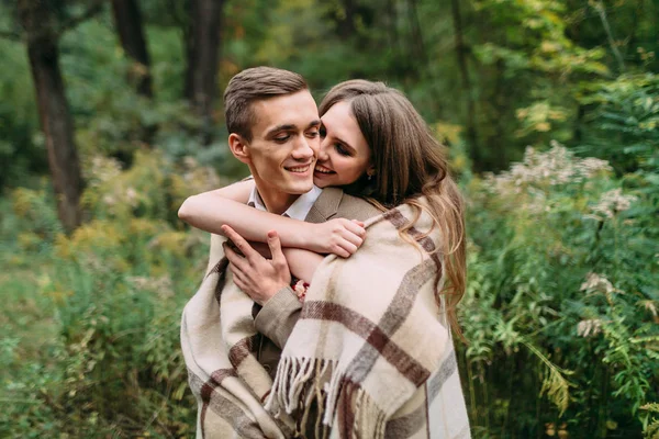 Beautiful girl is tenderly embracing her boyfriend by the plaid by behind. Happy newlyweds — Stock Photo, Image