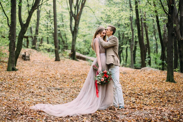 De pasgetrouwden in een herfst romantische forest. Huwelijk ceremonie buiten. — Stockfoto