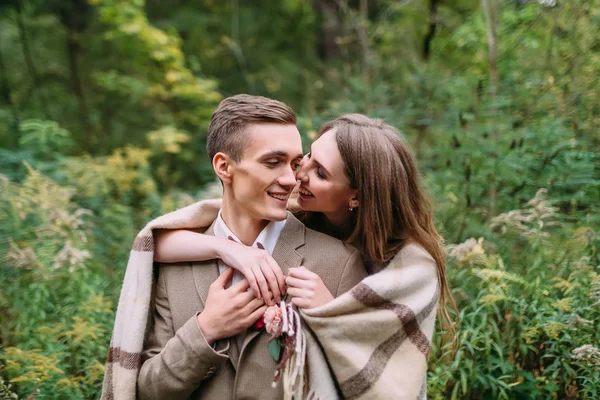 Couple under the plaid in an autumn romantic forest. Autumn wedding outdoors. — Stock Photo, Image