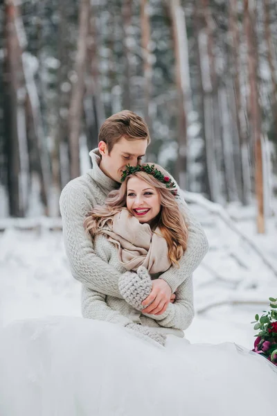 Heureux jeunes mariés sont câlins dans la forêt d'hiver. Couple amoureux. Cérémonie de mariage hiver . — Photo