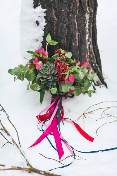 Ramo de boda rústico con suculentas y flores carmesí en la nieve junto al árbol. Al aire libre. Obra de arte —  Fotos de Stock