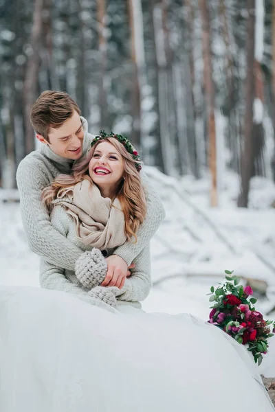 La novia y el novio se abrazan en el bosque de invierno. Pareja enamorada. Ceremonia de boda . —  Fotos de Stock