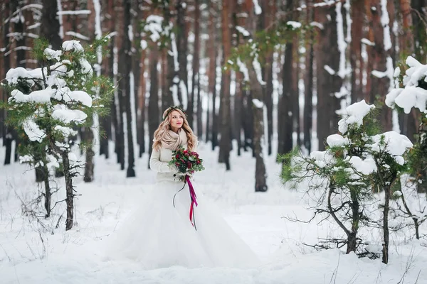 Красивая невеста позирует с букетом в заснеженном лесу. Зимняя свадьба. Озил работает . — стоковое фото