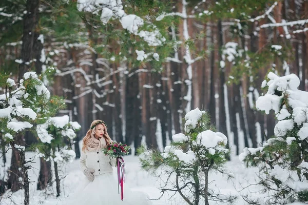 Молодая невеста позирует с букетом в снежном лесу. Зимняя свадьба. Озил работает . — стоковое фото