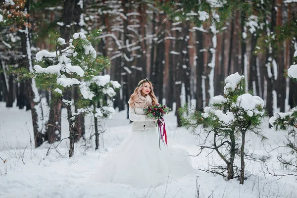Молодая невеста позирует с букетом в снежном лесу. Зимняя свадьба. Озил работает . — стоковое фото