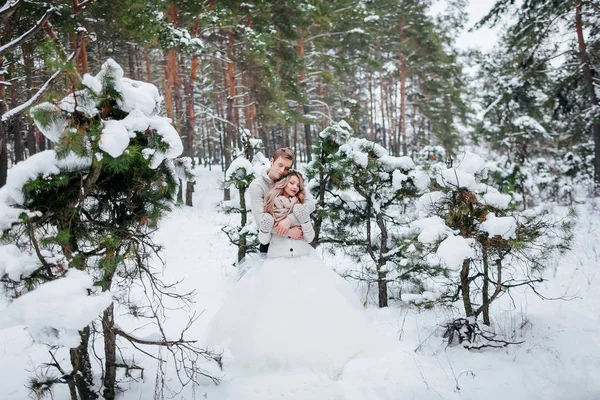 Милые молодожёны обнимаются в заснеженном лесу. Зимняя свадьба. Озил работает — стоковое фото