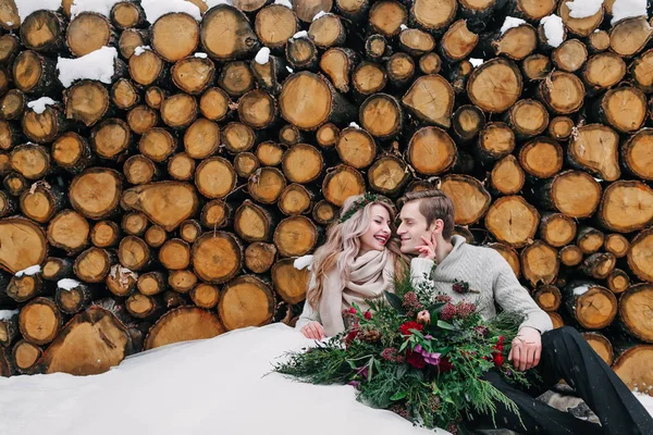 Bouquet de mariage d'hiver. Une oeuvre. Couple assis sur la neige sur le fond en bois . — Photo