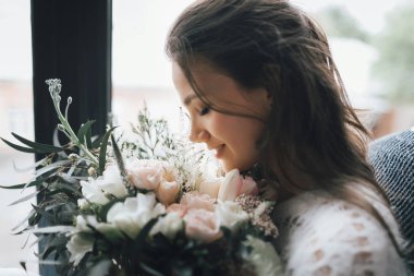 Bir demet çiçekle mutlu bir kızın yakın plan portresi. Sanat eserleri