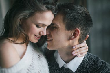 Birbirlerine aşık bir çiftin yakın plan portresi. Birbirlerine bakıyorlar ve alınlarına dokunuyorlar. Mutlu yeni evliler. Sanat eserleri