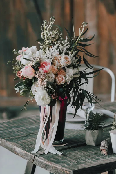 De samenstelling van de bloem met witte en roze rozen en andere bloemen op een rustieke tafel. Kunstwerk. Binnenshuis. — Stockfoto