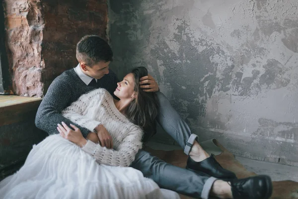 A noiva jovem no vestido de cadarço terno está em joelhos de um noivo bonito. Recém-casados alegres estão rindo. Comprimento total — Fotografia de Stock