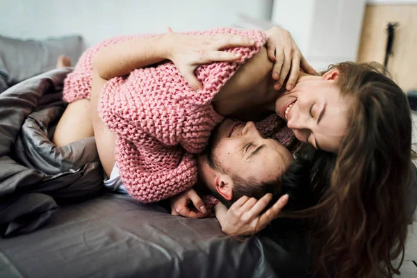 Sorridente giovane coppia sdraiata e abbracciata a letto a casa. Lavori preparatori . — Foto Stock