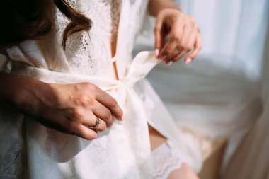 Bridal morning preparation. Selective focus on the hand with wedding ring clipart