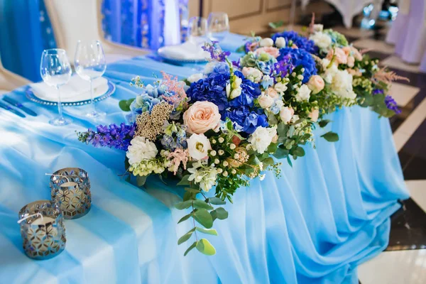 Dekorace Svatební hostina. Umělecká díla. Měkké zaostření na kytici s eustoma a modré hortenzie na modrý ubrus — Stock fotografie