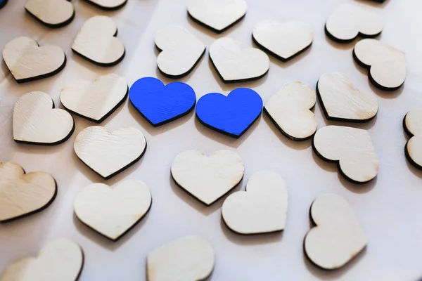Biały i niebieski rzeźbione drewniane serca na stole. Dzieła sztuki — Zdjęcie stockowe
