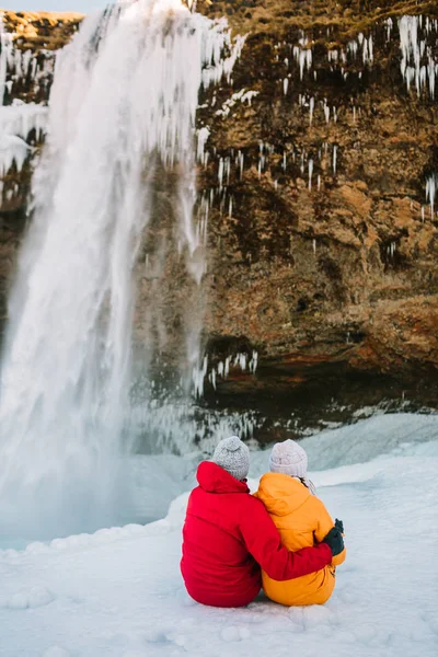 Casal viajante admira cachoeira. Islândia viajantes — Fotografia de Stock