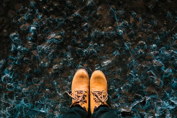 Um par de botas castanhas no fundo com textura de gelo. Islândia. Espaço de cópia — Fotografia de Stock