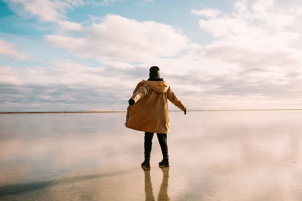Visão traseira de uma jovem mulher feliz desfrutando da viagem, olhando para cima e segurando as mãos no ar. Islândia viajando . — Fotografia de Stock