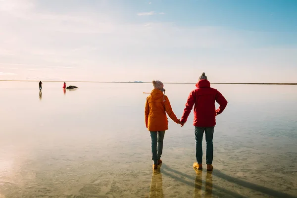 Muž v červené bundě a žena v žluté sako vycházkové společně na ledě. Cestovatele Island — Stock fotografie