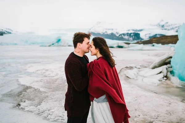 Novio besando tiernamente a su hermosa novia en la nariz. Alegre recién casados se está abrazando en la laguna glaciar, Islandia. .. Recién casados —  Fotos de Stock