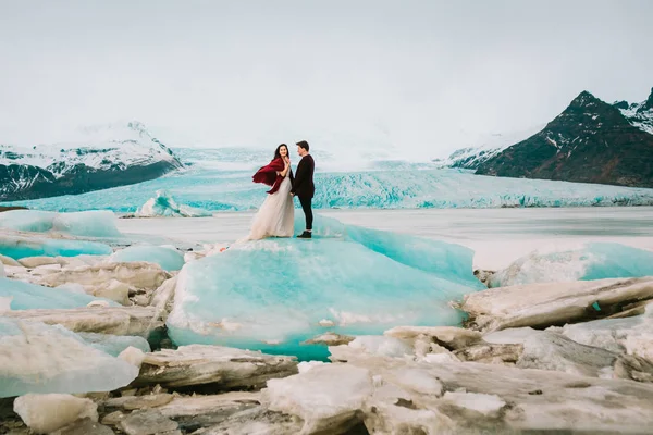 冰岛冰海滩或 Jokulsarlon 冰山海滩-新娘和新郎站在冰山上 — 图库照片