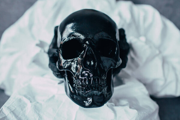 Черный череп держится руками вирусолога в вирусном защитном костюме и черных медицинских перчатках. Опасность смерти из-за эпидемии коронавируса. Риски и последствия этого ужасного вируса
.