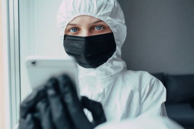 Viral koruyucu giysili doktor, ilaç maskesi ve eldiven giyen doktor kameraya korku ile bakıyor ve koronavirüsün yayılmasıyla ilgili karantinaya alınmış endişeleri var. Virolog virüs salgınından korkuyor..