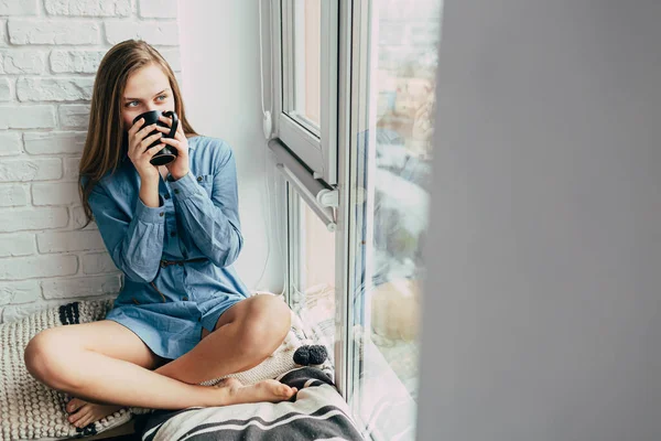 Dospívající Dívka Pije Kávu Černého Poháru Mladá Žena Sedí Parapetu — Stock fotografie