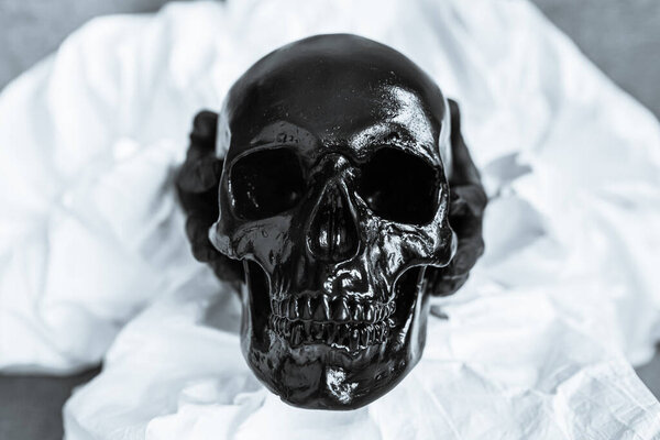 Черный череп держится руками вирусолога в вирусном защитном костюме и черных медицинских перчатках. Опасность смерти из-за эпидемии коронавируса. Смертность после этого ужасного вируса
.