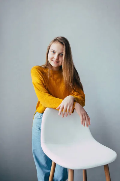 Έφηβη Κοπέλα Κοιτάζει Κάμερα Στέκεται Άπαχο Λευκό Μοντέρνα Καρέκλα Όμορφο — Φωτογραφία Αρχείου