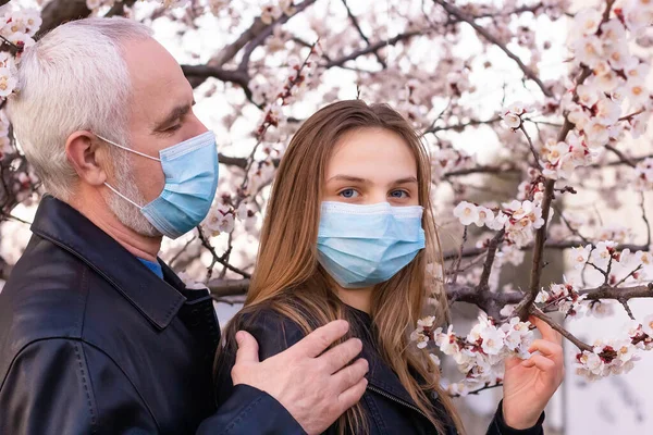마스크쓴 소녀와 할아버지 정원에서 있으면서 세계적 전염병 지원하는 — 스톡 사진