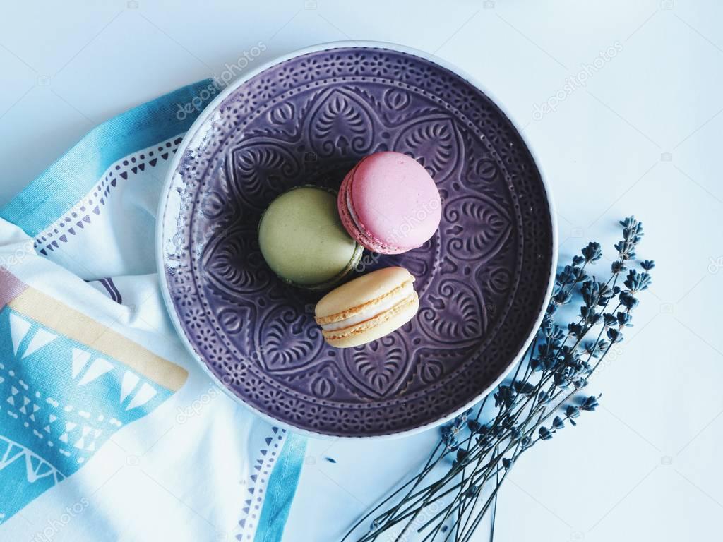 Top view of Tender vintage stylish macarons with lavender on plate on table White background.