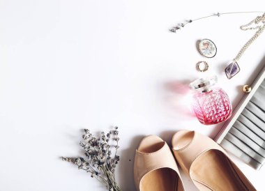 Kadınsı güzel beyaz arka plan, kozmetik, çiçekler, çanta, parfüm. Aksesuarlar, çıplak ayakkabı. Üstten Görünüm. Moda arka plan. Güzellik ürünleri. Metin için yer. Gelin.